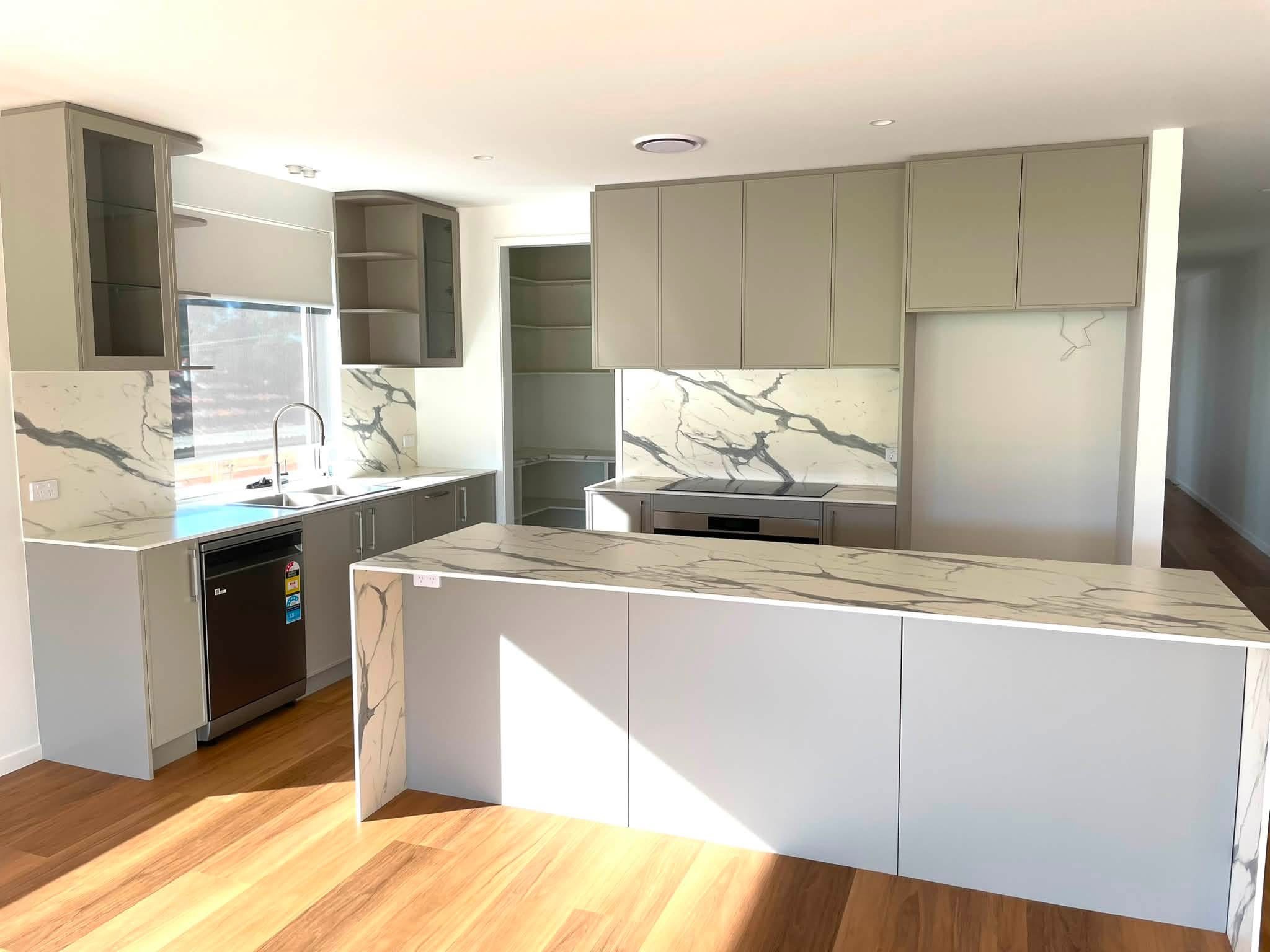 Sage green kitchen with a marble-look island, built by Central Coast Joinery