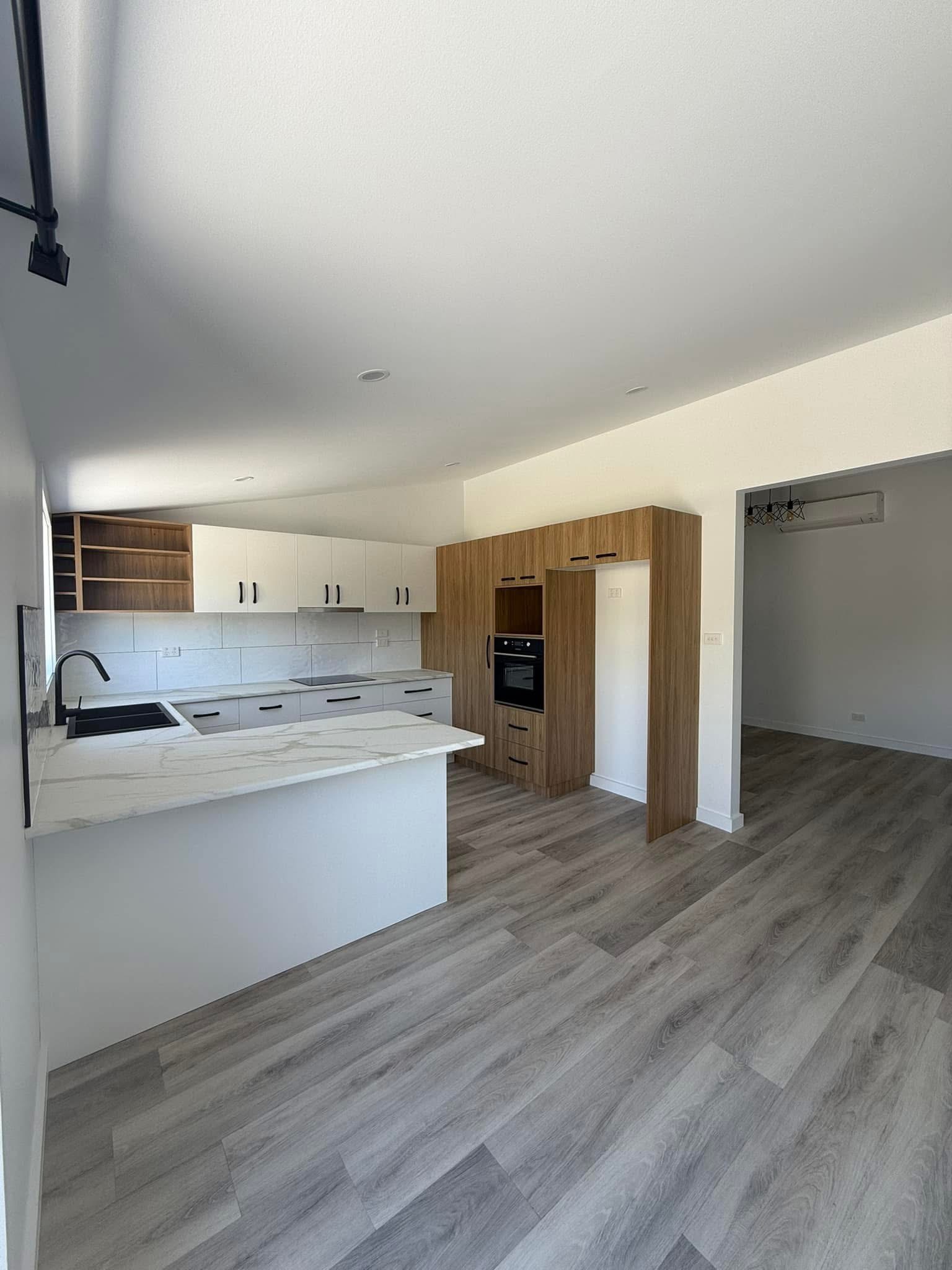 White kitchen with woodgrain cabinetry, built by Central Coast Joinery
